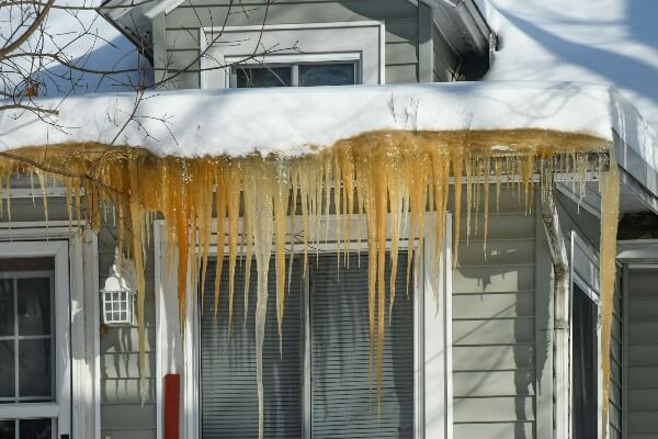 Problems become more likely for your home when you leave an old or worn out roof through just one more winter. This photo shows an old roof covered in snow.